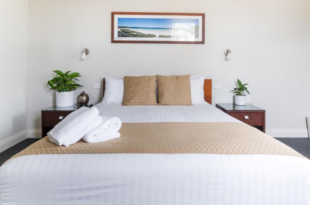 赫斯基森Huskisson Hotel的卧室里有一张白色的大床，床上放着毛巾