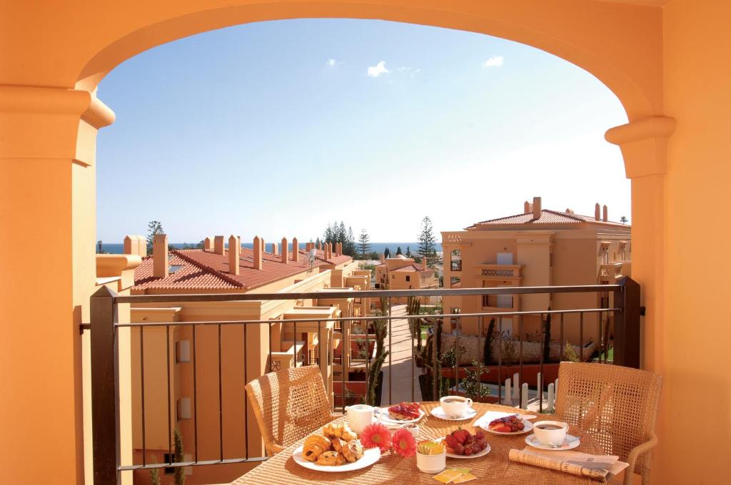 a table with food on top of a balcony at Baia da Luz Resort in Luz