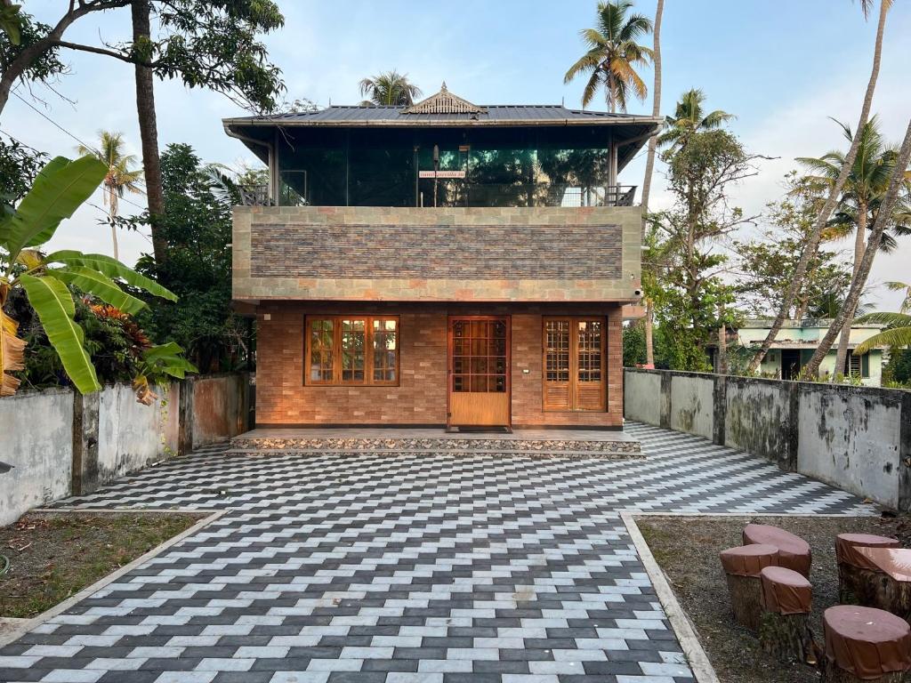 a house in the middle of a courtyard at Sunshine Beach Villa - Kuzhuppilly in Cherai Beach