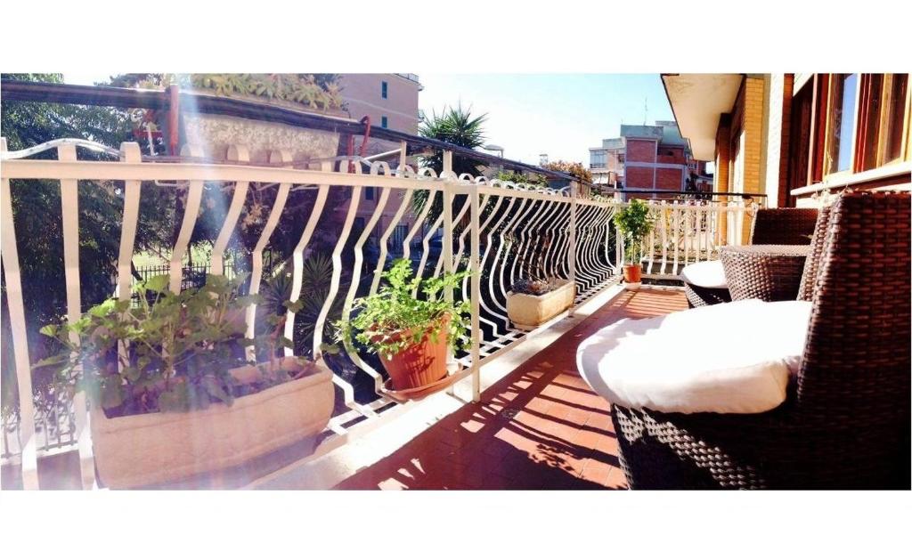 een balkon met stoelen en potplanten op een gebouw bij Casa Celeste in Rome