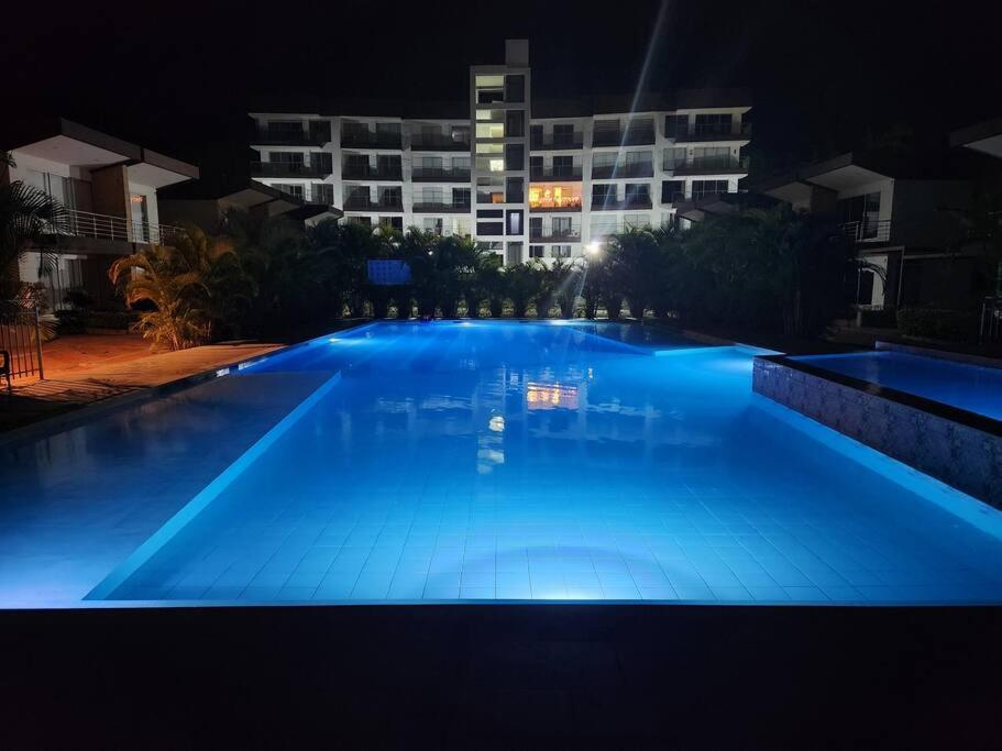a large swimming pool at night with a building at Precioso apartamento para disfrutar en familia in Villeta