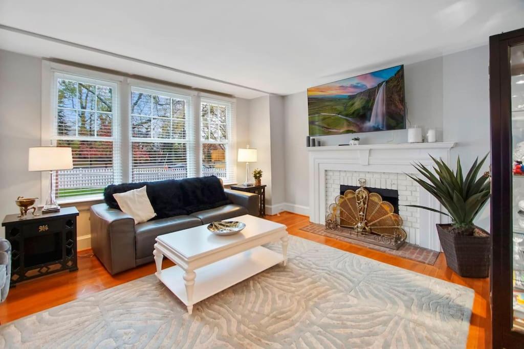 uma sala de estar com um sofá e uma lareira em Chevy Chase 3 BR Chic Comfortable Spacious Luxury em Washington