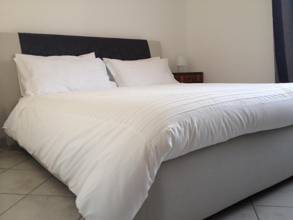 a large white bed with white sheets and pillows at Via Roma suite in Ortona