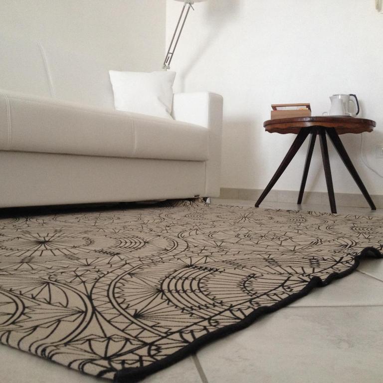 a living room with a rug with a couch and a table at Via Roma suite in Ortona