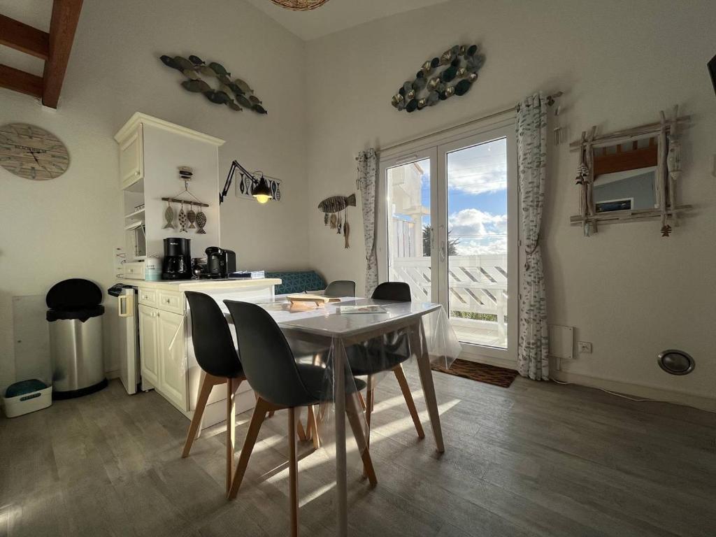 une cuisine avec une table et des chaises et une fenêtre dans l'établissement Appartement cosy 2 pièces, 4 couchages, vue mer, proche port, WIFI, parking, plage à St-Pierre-d'Oléron - FR-1-246A-170, à Saint-Pierre-dʼOléron