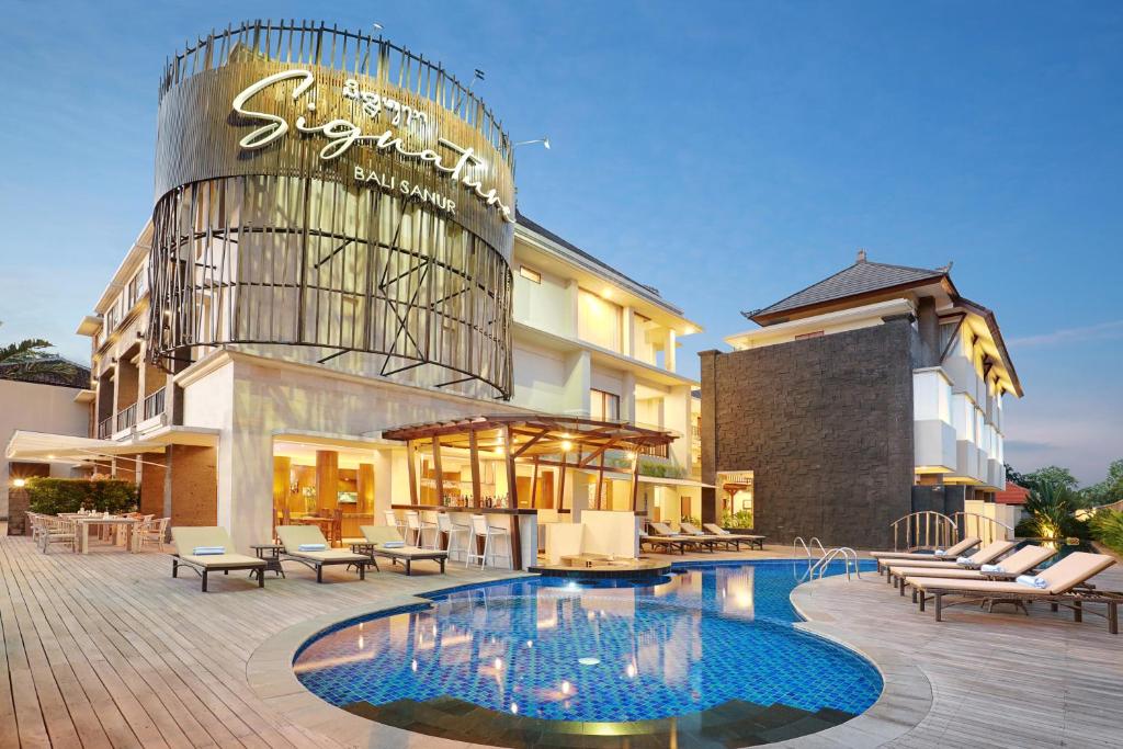 een hotel met een zwembad voor een gebouw bij Townhouse OAK Signature Bali in Sanur
