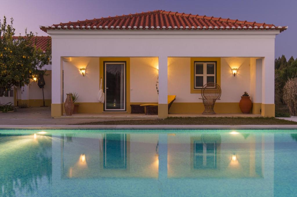 une villa avec une piscine en face d'une maison dans l'établissement Monte Macário Alojamento Local, à Coruche