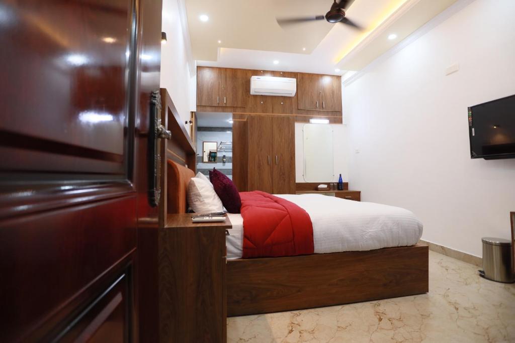 a bedroom with a bed with a red blanket at Kausthubhom Residency in Tiruvalla