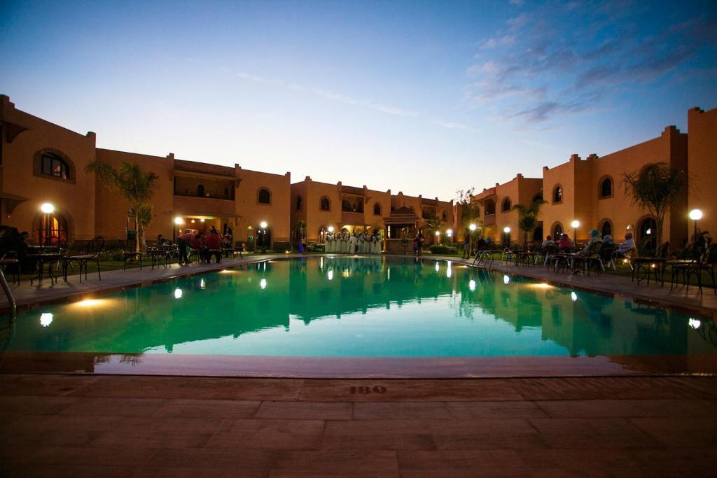 - une piscine au milieu d'une cour la nuit dans l'établissement Charming apartment - secure and close to Marrakech, à Tahannaout