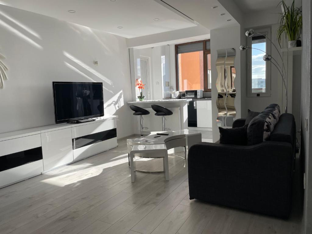 ein Wohnzimmer mit einem Sofa und einem TV in der Unterkunft Luxury Two Room Apartment Residence Militari M3 in Bukarest