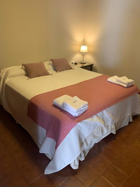 a bedroom with a large bed with towels on it at Los Naranjos Departamentos 2 in Concepción
