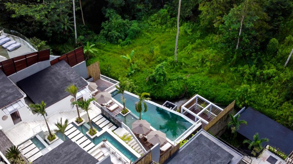 an overhead view of a swimming pool with palm trees at Villa Mugiwara by BaliSuperHost in Ubud