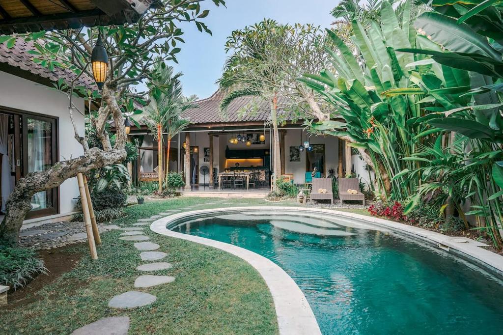 a swimming pool in the yard of a house at Contemporary Balinese 4BR Private Villa in Umalas in Kerobokan