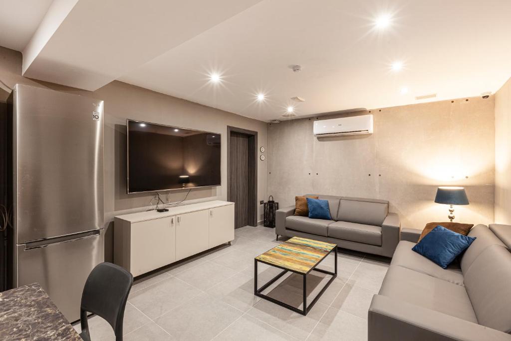 un soggiorno con divano e TV a schermo piatto di Charming,Comfortable and Centrally located Group Accomodation a Il-Gżira