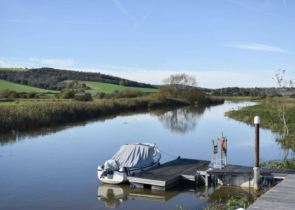 a boat is docked at a dock on a river at Riverside Holiday Park in Amberley