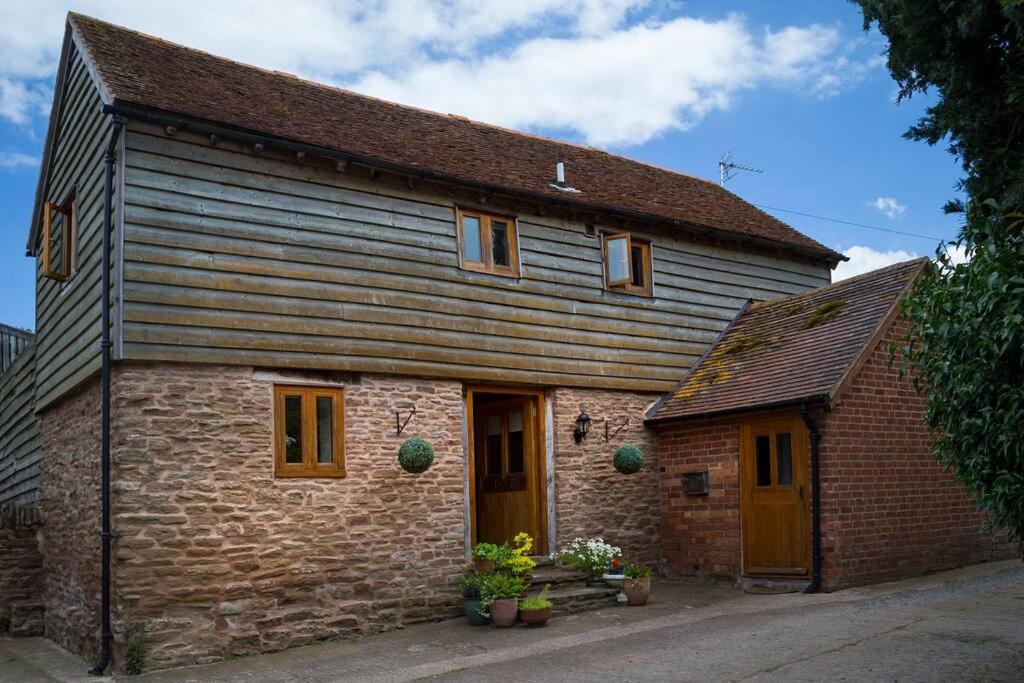 an old stone house with a brown roof at Coach House - detached cottage within 135 acres in Bromyard