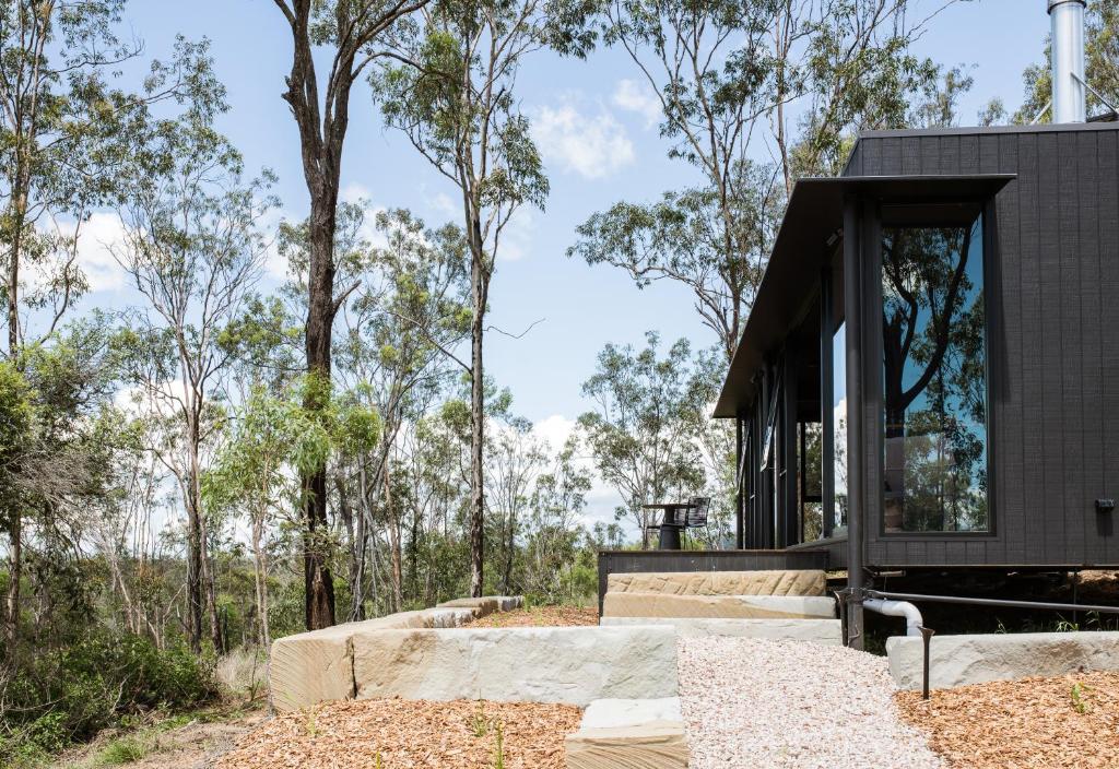 a house in the woods with a black facade at Wander in the Scenic Rim in Wyaralong