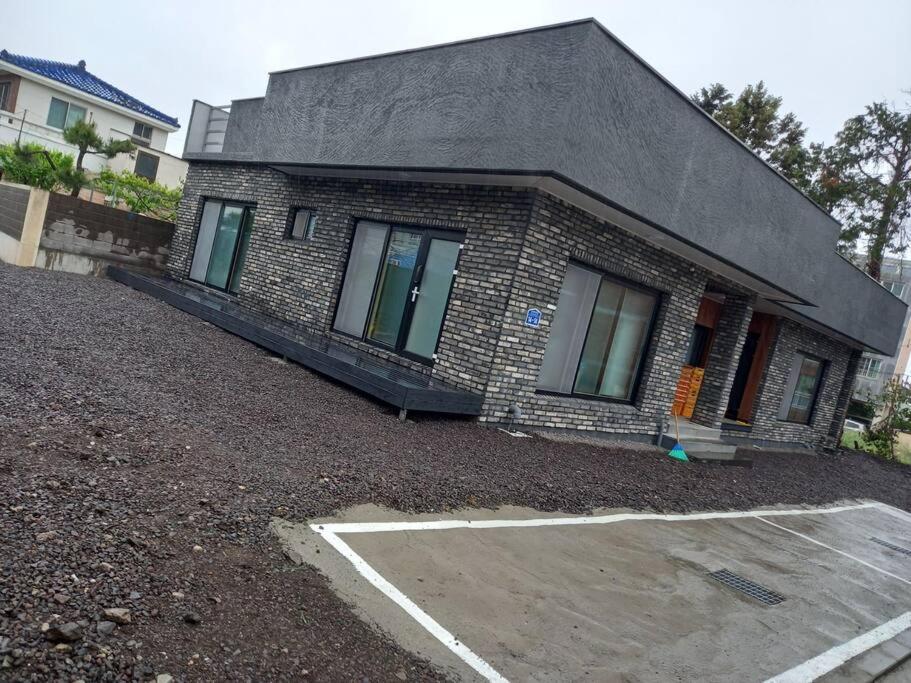 a brick house with a parking lot in front of it at Summer's House in Jeju