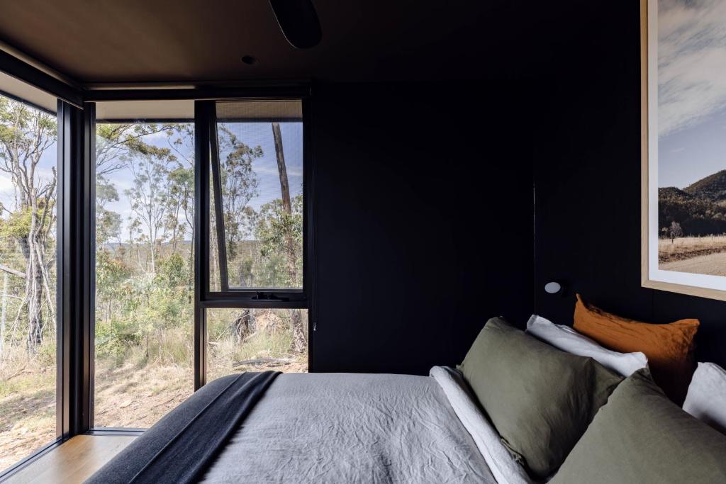 a bedroom with a bed and a large window at Wander in the Scenic Rim in Wyaralong