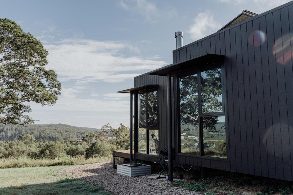 a black house with large windows on the side of it at Wander in the Scenic Rim in Wyaralong