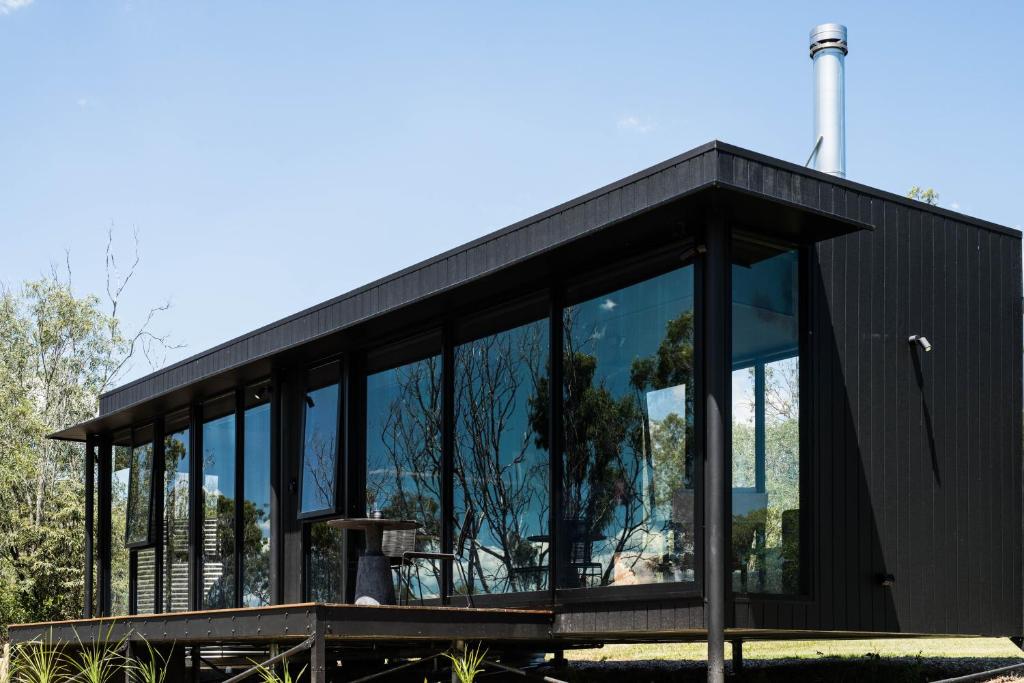 a black house with large glass windows at Wander in the Scenic Rim in Wyaralong