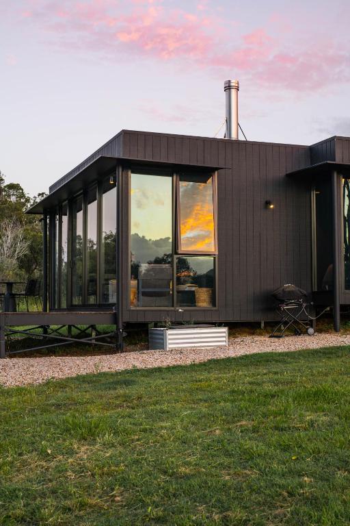 a black house with large windows on the grass at Wander in the Scenic Rim in Wyaralong