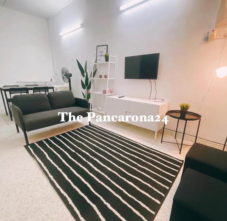 ein Wohnzimmer mit einem Sofa und einem TV in der Unterkunft The Pancarona24 Homestay forMuslim in Ipoh