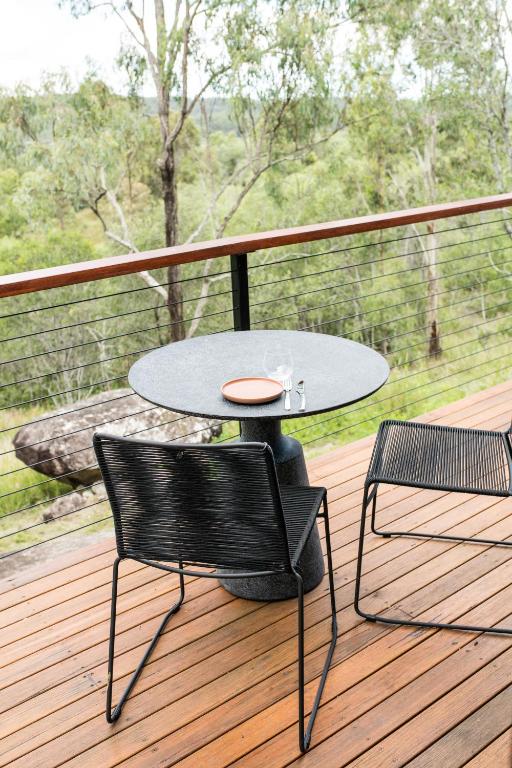 a table and two chairs on a deck at Wander in the Scenic Rim in Wyaralong