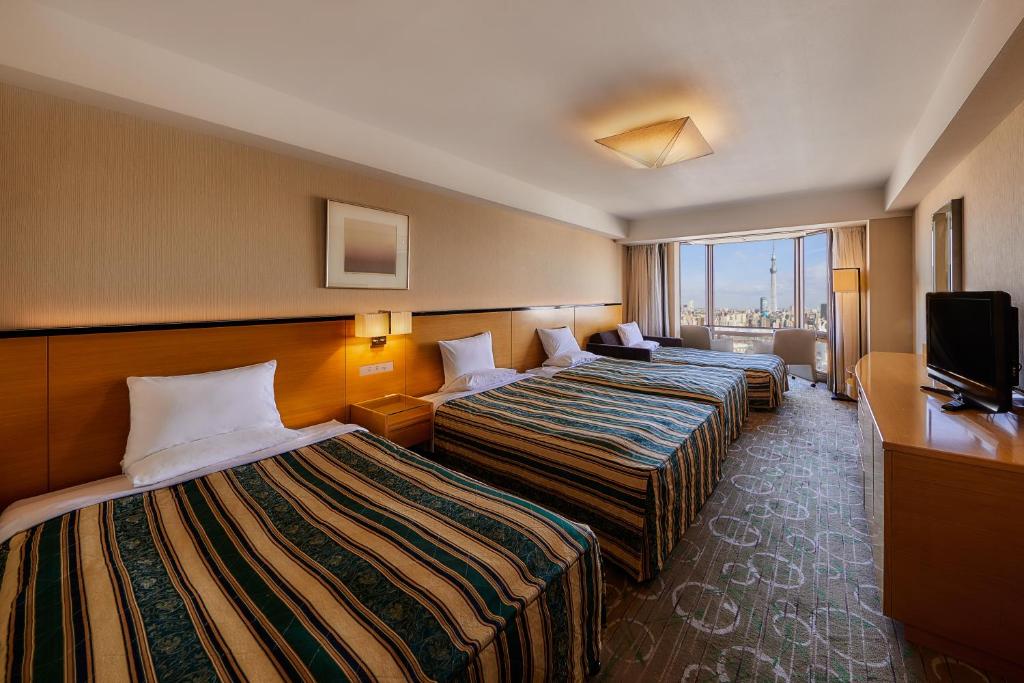 Postel nebo postele na pokoji v ubytování Asakusa View Hotel
