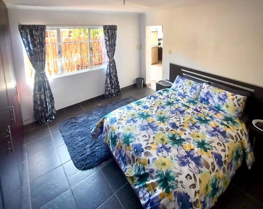 een slaapkamer met een bed en een raam met gordijnen bij Morningview Cottage - Self Catering Private Owned Rental in Durban