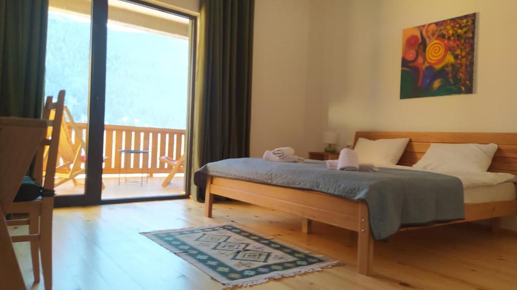 sypialnia z łóżkiem i przesuwnymi szklanymi drzwiami w obiekcie Hotel Lamish w mieście Mestia