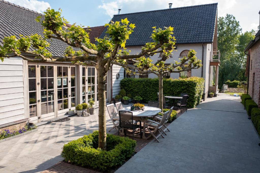 a garden with a table and chairs and a tree at Bed and Breakfast Paellepelhoeve in Ninove