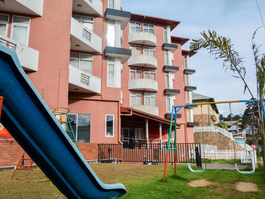a playground with a slide in front of a building at Breeze Holiday Casa in Nuwara Eliya