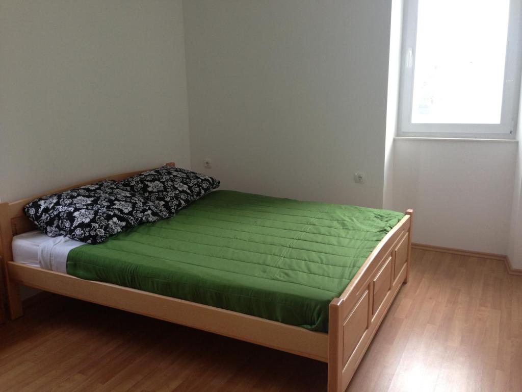 a bedroom with a bed with a green mattress and a window at Beach House Murter in Murter