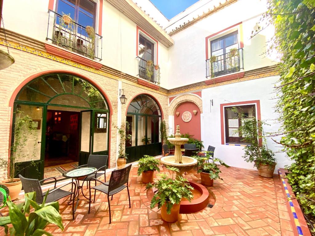 an outdoor patio with chairs and tables and plants at El Rincón de las Descalzas in Carmona