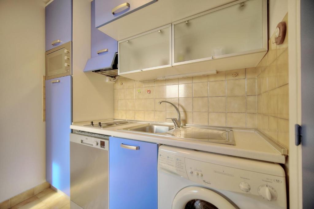 a small kitchen with a sink and a dishwasher at Very pleasant 2 rooms garage near the beaches in Cannes