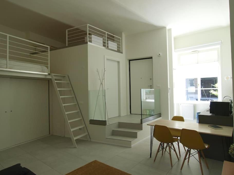 une chambre avec un escalier, une table et des chaises dans l'établissement Il loft sotto la Mole, à Turin