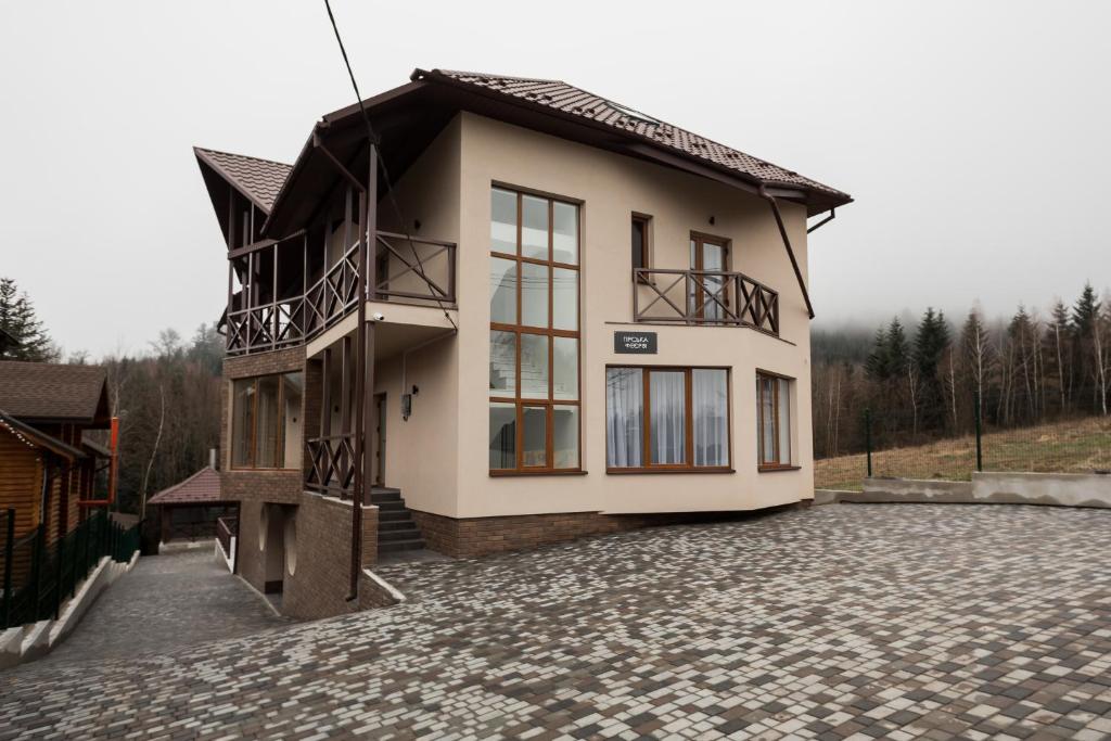 une maison avec un balcon dans une allée en pierre dans l'établissement Гірська феєрія, à Myhove