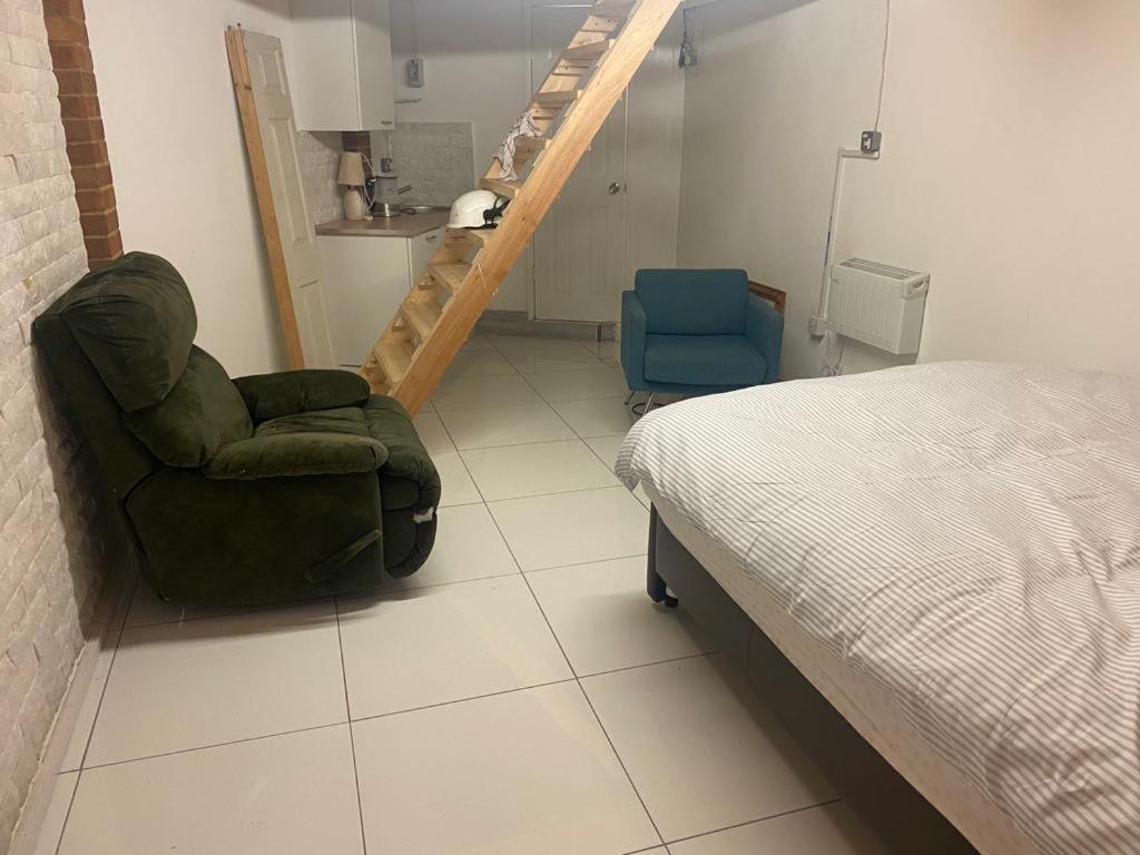um quarto com uma cama, uma cadeira e uma escada em Parkview em Hoo