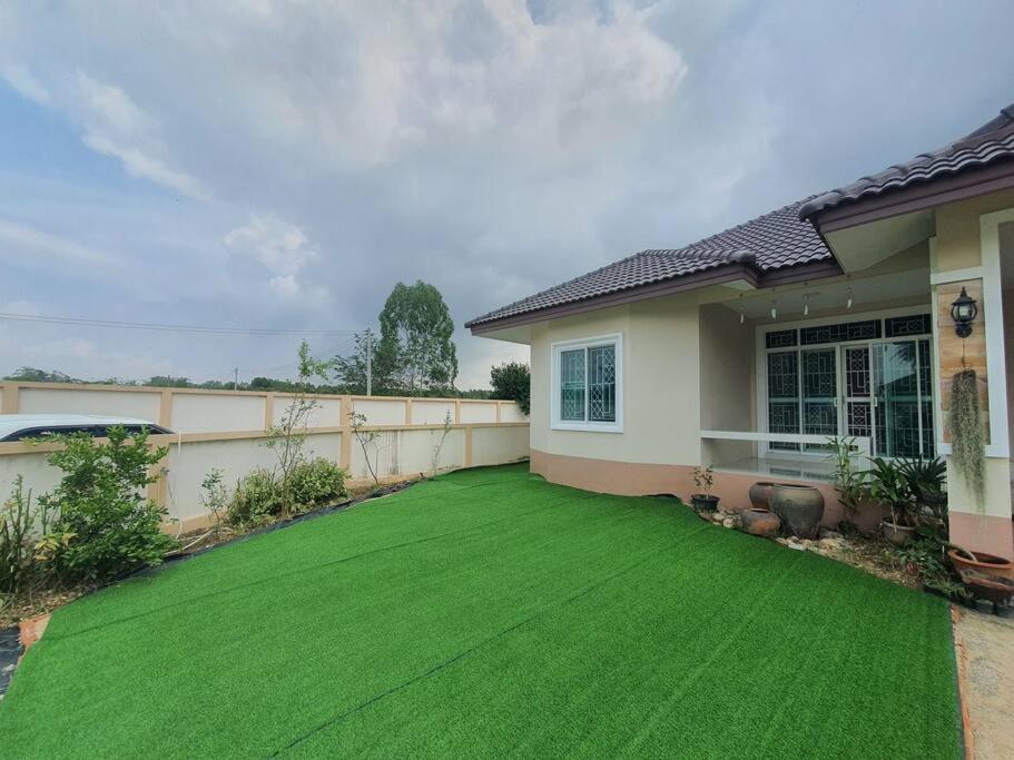 a yard of a house with a green lawn at house near natureบ้านใกล้ธรรมชาต in Ban Nong Sa