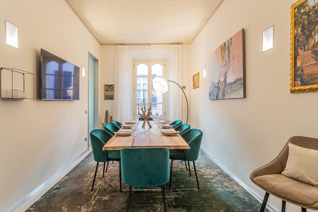 comedor con mesa y sillas verdes en Rovelli 41 by Rent All Como, en Como