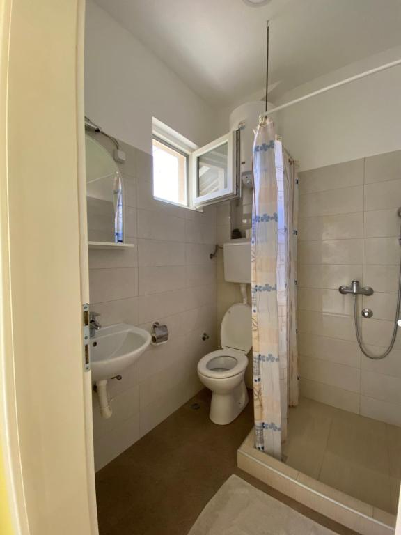 uma casa de banho com um WC, um lavatório e um chuveiro em Maslina Rooms em Smederevo