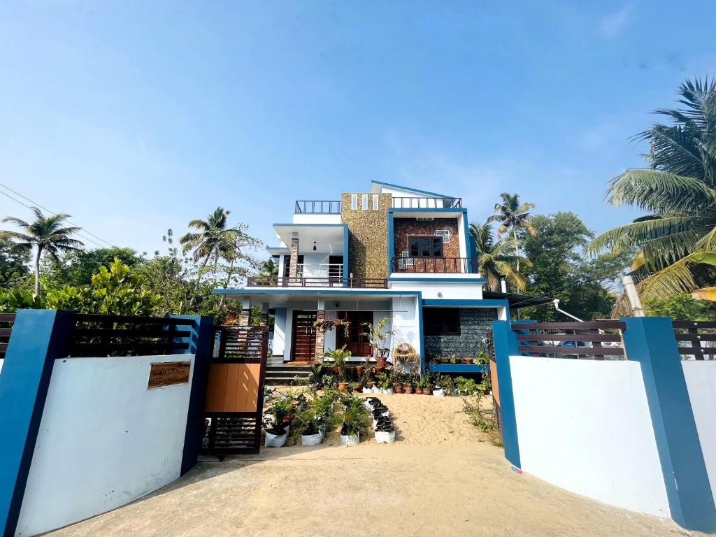 una casa en la playa frente a una puerta en MALHAR MARARI HOMESTAY, en Mararikulam