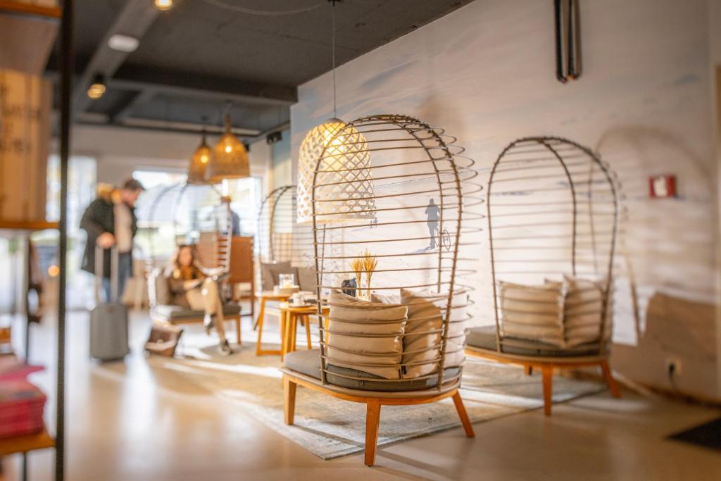 une pièce avec deux chaises et tables dans un magasin dans l'établissement SAND Lifestylehotel, à Timmendorfer Strand