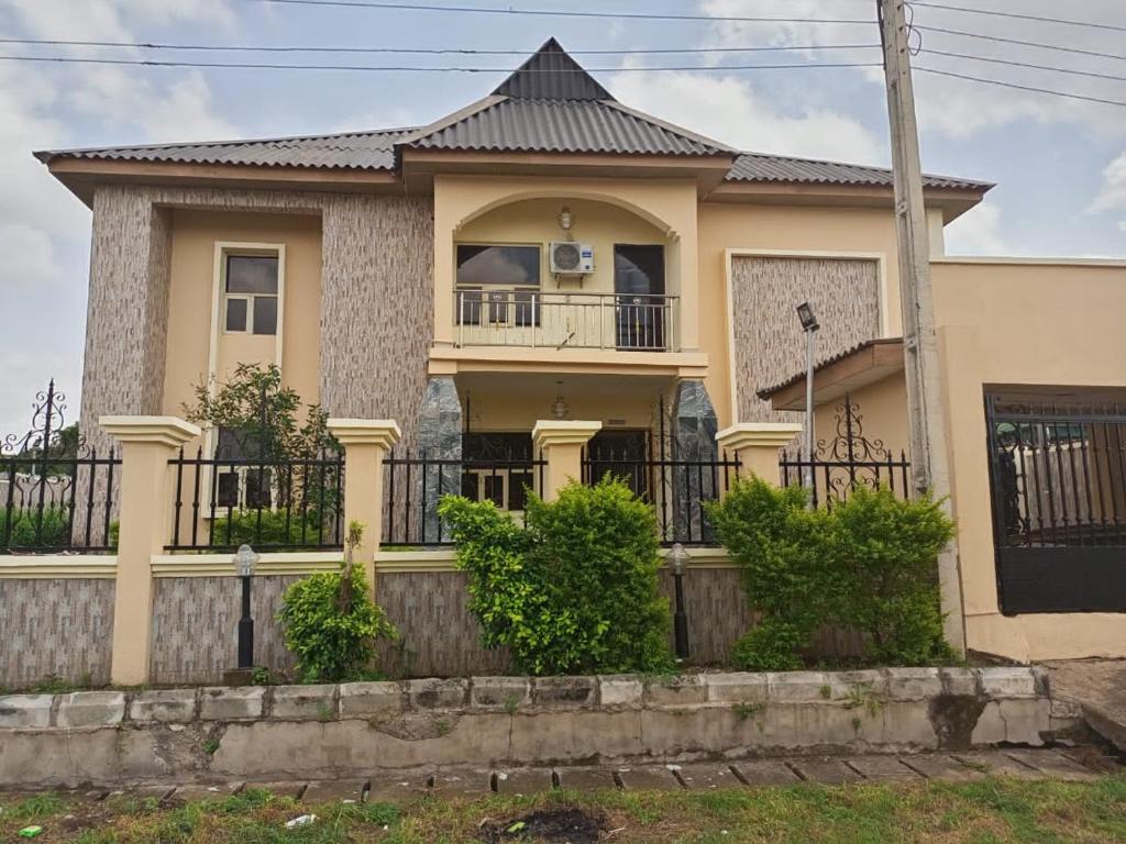 a house with a fence in front of it at Torax Lodge in Ibadan