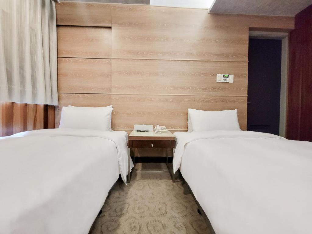two beds sitting next to each other in a room at CHECK inn Express Taichung Fengchia in Taichung