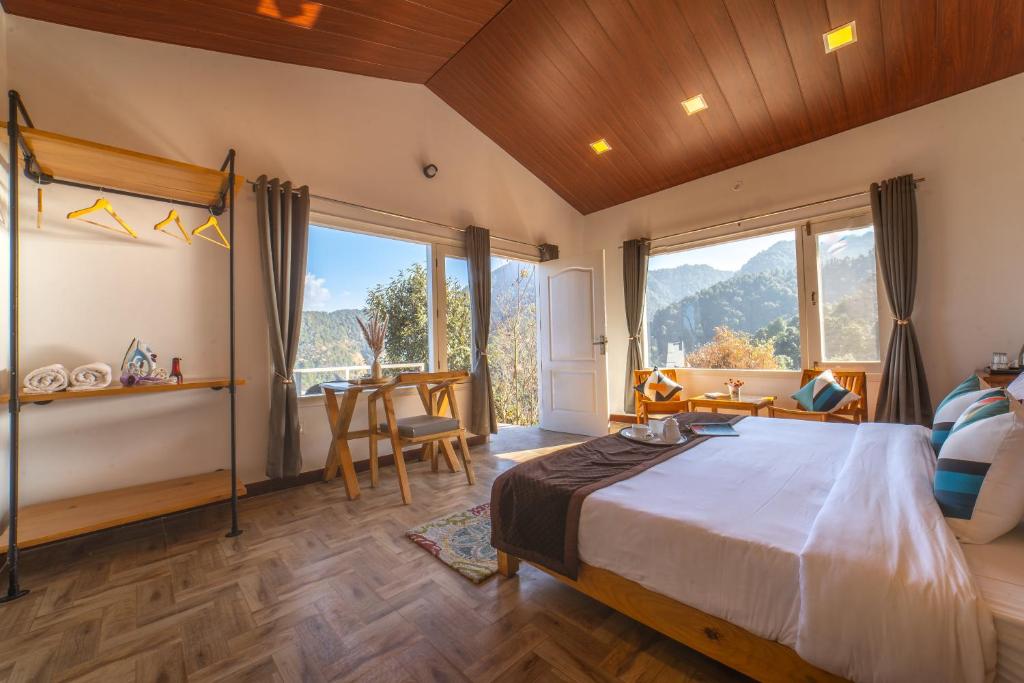 Zostel Plus Nainital (Naina Range) في ناينيتال: غرفة نوم بسرير كبير في غرفة بها نوافذ