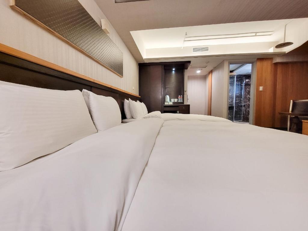 a large white bed in a hotel room at CHECK inn Express Taichung Fengchia in Taichung