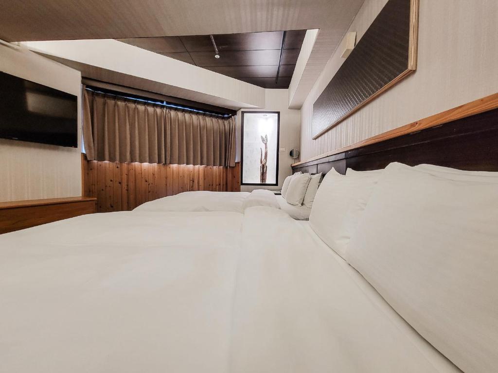 a bedroom with a large bed with white sheets at CHECK inn Express Taichung Fengchia in Taichung