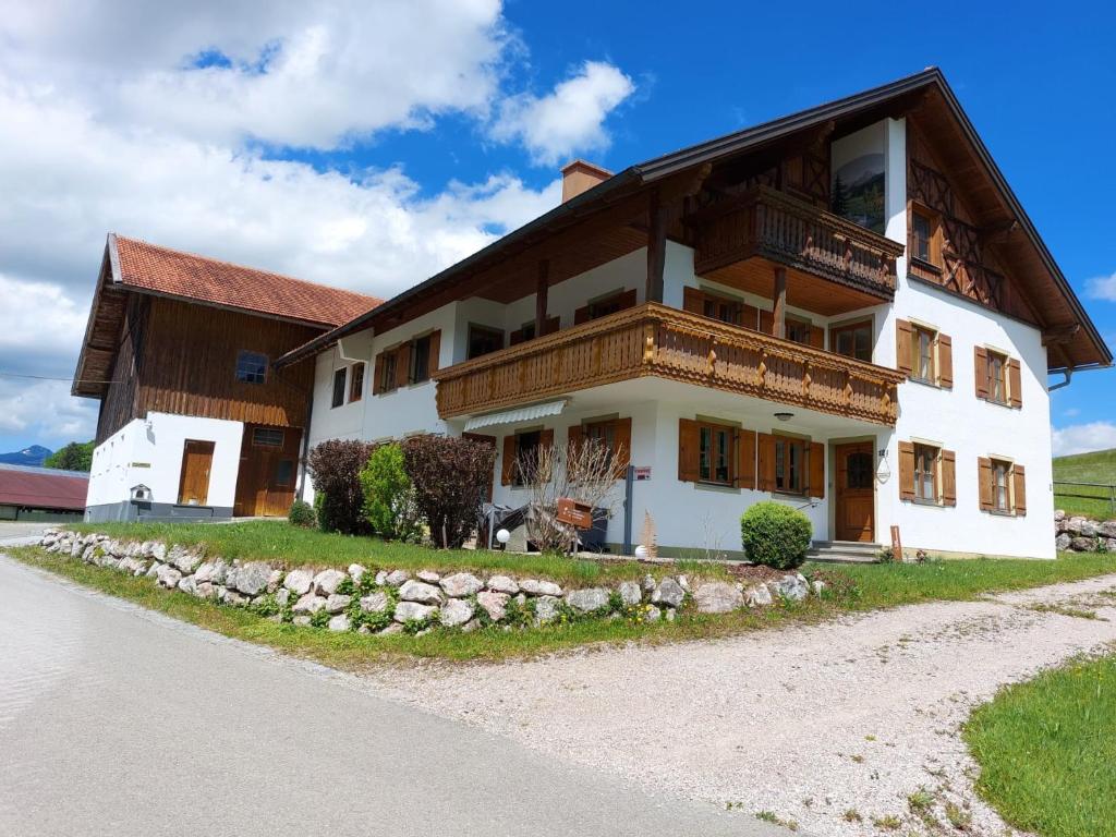 a large white building with a wooden roof at Haus Guggemos in Hopferau